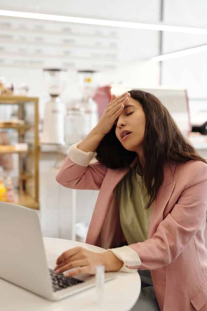 A Woman Looking Sick while Working with Her Laptop